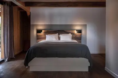 a bedroom with a large bed with two pillows at Chalet de 8 chambres MEGEVE - 16 personnes in Megève