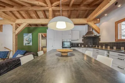 a kitchen and dining room with a large wooden table at Chalet Minouche in Chamonix-Mont-Blanc