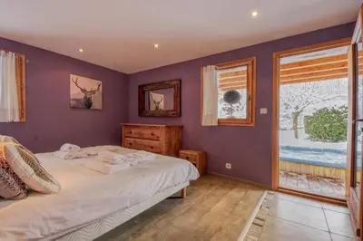 a bedroom with purple walls and a bed and a window at Chalet Minouche in Chamonix-Mont-Blanc