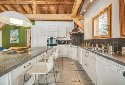 a kitchen with white cabinets and a wooden ceiling at Chalet Minouche in Chamonix-Mont-Blanc