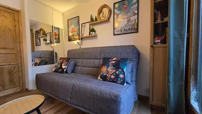 a couch with a picture of a man on it in a living room at Appartement proche télécabine! Séjour tout inclu! in Les Contamines-Montjoie