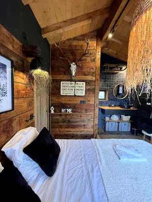 a bedroom with a bed with a deer head on the wall at Chalet ski-in-out face au MontBlanc & Bain nordique in Megève