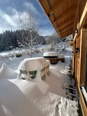 a snow covered porch of a house with a bench at Chalet ski-in-out face au MontBlanc & Bain nordique in Megève