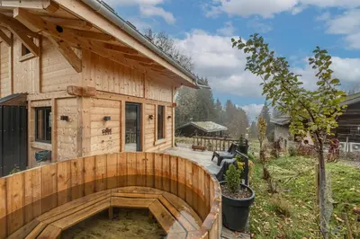 a wooden house with a wooden walkway in front of it at Chalet ski-in-out face au MontBlanc & Bain nordique in Megève