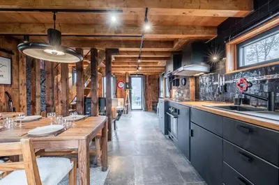 a kitchen with a long table and wooden counters at Chalet ski-in-out face au MontBlanc & Bain nordique in Megève