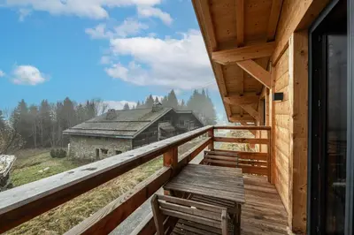 a wooden balcony with a view of a house at Chalet ski-in-out face au MontBlanc & Bain nordique in Megève