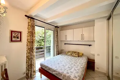 a bedroom with a bed and a large window at Apartment 2 rooms near the slopes in Combloux