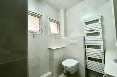 a white bathroom with a toilet and a sink at Apartment 2 rooms near the slopes in Combloux