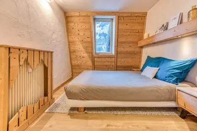 a bedroom with a bed in a room with wooden walls at Apt Le Lyret in Chamonix-Mont-Blanc