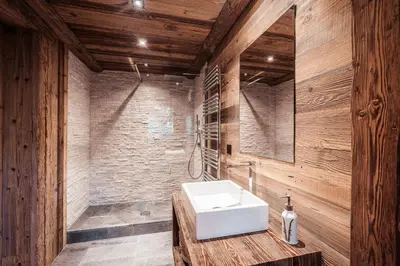a bathroom with a white sink and wooden walls at Belmont - New & ecological chalet in the heart of Combloux in Combloux