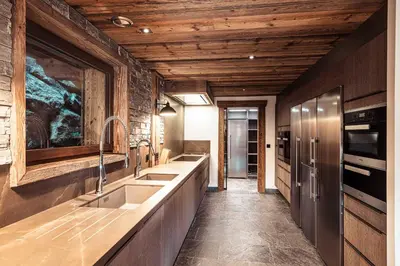 a kitchen with two sinks and a wooden ceiling at Belmont - New & ecological chalet in the heart of Combloux in Combloux