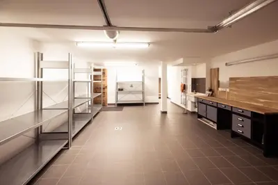 a large kitchen with stainless steel cabinets and a tile floor at Belmont - New & ecological chalet in the heart of Combloux in Combloux