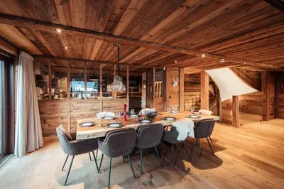 a dining room with a large wooden table and chairs at Belmont - New & ecological chalet in the heart of Combloux in Combloux