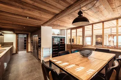 a kitchen and dining room with a wooden table and chairs at Belmont - New & ecological chalet in the heart of Combloux in Combloux