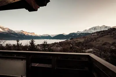 a view of a lake and snow covered mountains at Belmont - New & ecological chalet in the heart of Combloux in Combloux
