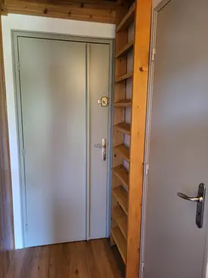 a door leading to a closet with wooden shelves at Studio Mezzanine Les Combettes E in Les Contamines-Montjoie