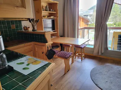 a kitchen with a wooden table and a counter top at Studio Mezzanine Les Combettes E in Les Contamines-Montjoie