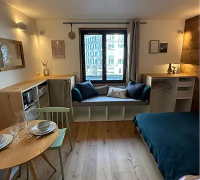 a living room with a couch and a table at Charming Mont-Blanc View Studio in Chamonix in Chamonix-Mont-Blanc