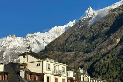 a building in front of a mountain with snow at Charming Mont-Blanc View Studio in Chamonix in Chamonix-Mont-Blanc