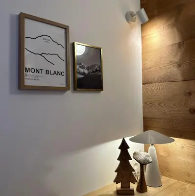 a room with two pictures on the wall and a lamp at Charming Mont-Blanc View Studio in Chamonix in Chamonix-Mont-Blanc