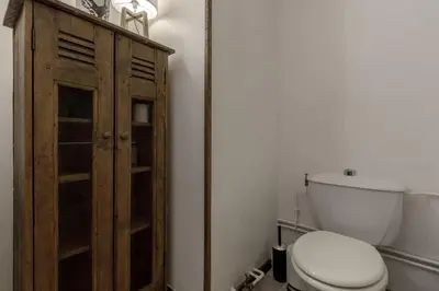 a bathroom with a toilet and a wooden cabinet at Le Miage in Chamonix-Mont-Blanc