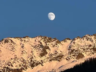 a moon over a snow covered mountain at Le Miage in Chamonix-Mont-Blanc