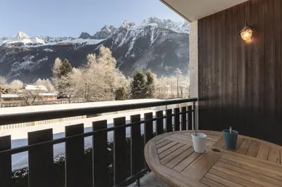 a table on a balcony with a view of a mountain at Le Miage in Chamonix-Mont-Blanc