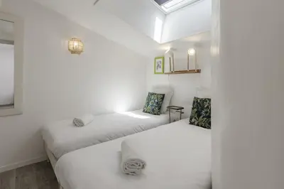two beds in a room with white walls at Le Triolet - Centre-ville - Balcon avec vue in Chamonix-Mont-Blanc