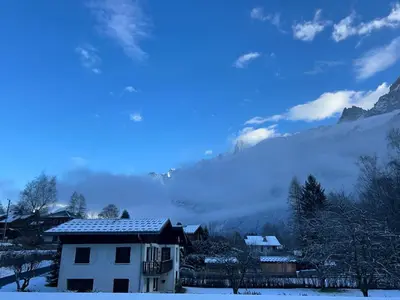 a house in the snow with a view of a mountain at Le Triolet - Centre-ville - Balcon avec vue in Chamonix-Mont-Blanc