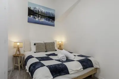 a bedroom with a black and white bed with two lamps at Le Triolet - Centre-ville - Balcon avec vue in Chamonix-Mont-Blanc