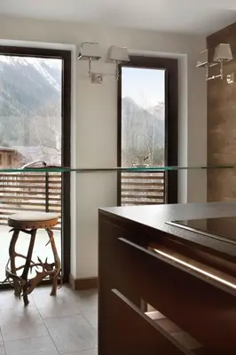 a kitchen with a glass counter and a stool at Chalet Alta in Chamonix-Mont-Blanc