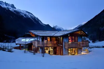 a log cabin in the snow with mountains at Chalet Alta in Chamonix-Mont-Blanc