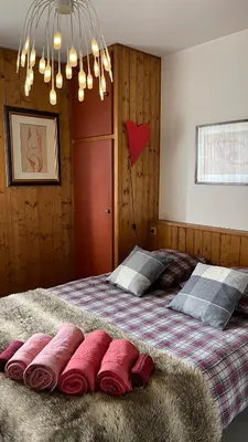 a bedroom with a large bed with pink pillows on it at Flocon U Bon Slo Megeve 2 in Megève