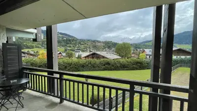 a balcony with a view of a field and mountains at Flocon U Bon Slo Megeve 2 in Megève