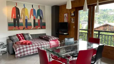 a living room with a couch and a table with chairs at Flocon U Bon Slo Megeve 2 in Megève