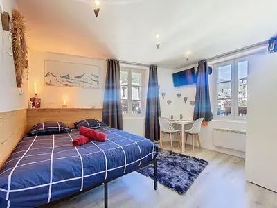 a bedroom with a bed with red pillows on it at Petit STUDIO STAR CHAMONIX HYPER CENTRE in Chamonix-Mont-Blanc