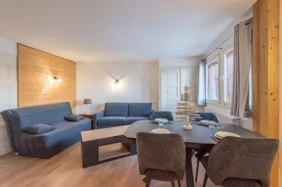 a living room with a blue couch and a table at Appartement Cimes Étoilées - Welkeys in Megève