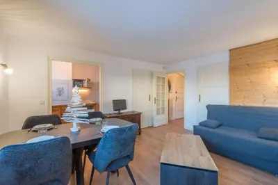 a living room with a blue couch and a table at Appartement Cimes Étoilées - Welkeys in Megève