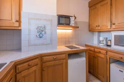 a kitchen with wooden cabinets and a microwave at Appartement Cimes Étoilées - Welkeys in Megève
