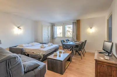 a living room with a bed and a table at Appartement Cimes Étoilées - Welkeys in Megève