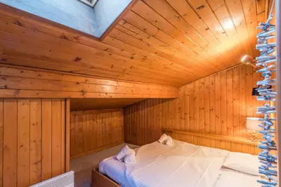 a bedroom with a bed in a wooden room at Appartement Cimes Étoilées - Welkeys in Megève
