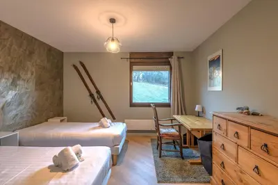 a bedroom with two beds and a desk and a table at Appartement Alpestre - Welkeys in Combloux