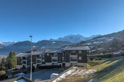 an apartment building with mountains in the background at Appartement Alpestre - Welkeys in Combloux