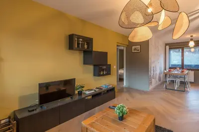 a living room with a television and a table at Appartement Alpestre - Welkeys in Combloux