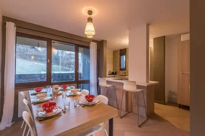 a kitchen and dining room with a table and chairs at Appartement Alpestre - Welkeys in Combloux