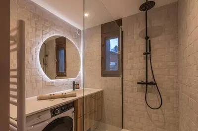 a bathroom with a washing machine and a shower at Appartement Alpestre - Welkeys in Combloux