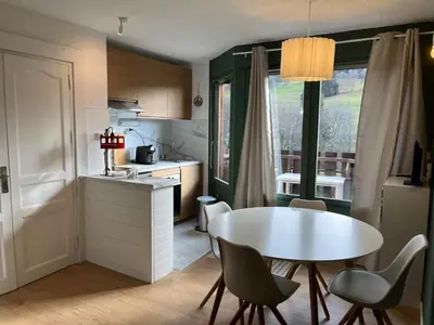 a kitchen with a white table and chairs and a table at Mignon petit Studio 25m2 avec balcon et Parking face départ pistes ! in Demi-Quartier