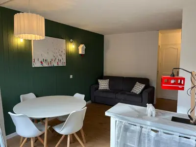a living room with a white table and a couch at Mignon petit Studio 25m2 avec balcon et Parking face départ pistes ! in Demi-Quartier