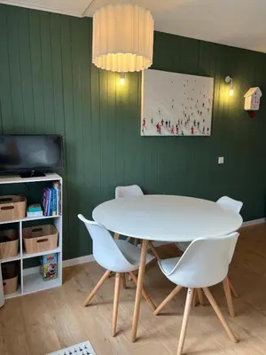 a dining room with a white table and chairs at Mignon petit Studio 25m2 avec balcon et Parking face départ pistes ! in Demi-Quartier