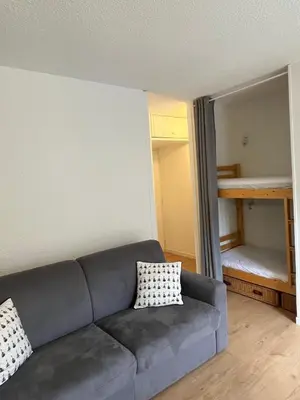 a living room with a couch and a bunk bed at Mignon petit Studio 25m2 avec balcon et Parking face départ pistes ! in Demi-Quartier
